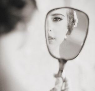鏡で背中を見る女性